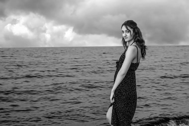 a girl walking at the beach black and white at the beach
