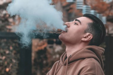 Bir adam kafede nargile içiyor ve dinleniyor.