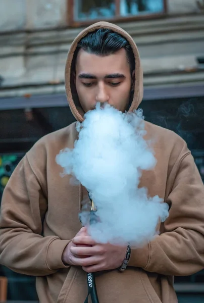Чоловік палить кальян в кафе і розслабляється — стокове фото