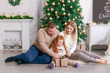 Aile Noel hediyelerini evde açıyor.