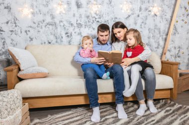 Dost bir aile Noel 'de kitap okuyor.