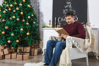 Adam Noel odasında kitap okuyor.