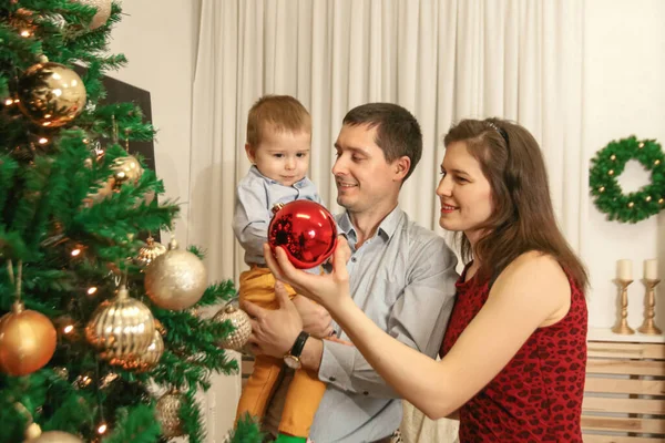 Happy Family decorate Christmas tree at home