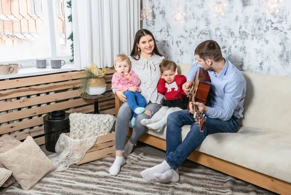 Szczęśliwa rodzina gra na gitarze na zdjęciu świątecznym — Zdjęcie stockowe