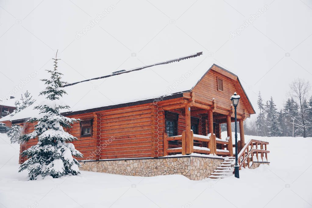 wooden house in the winter next to the winter forest