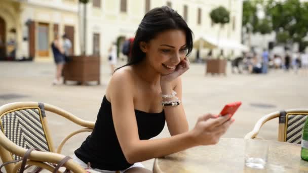 브라티슬라바의 역사적 지역에 테라스 위에서 핸드폰을 가지고 아름다운 미소짓는 비디오 — 비디오