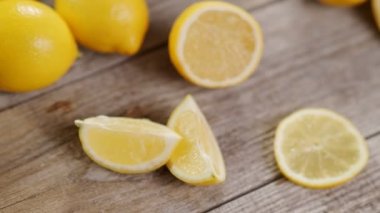 Bir fincan limon dilimli siyah çay ve 4K Video 'da gri ahşap masada bolca limon. Soğuk sonbahar ve kış günleri için sıcak içecek. C vitamini ile soğuk algınlığını önleme kavramı