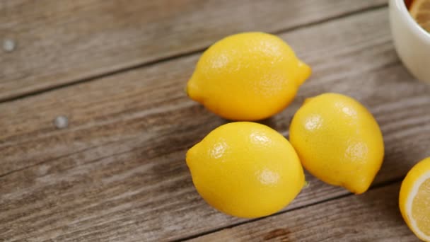 4Kビデオでは レモンスライスとグレーの木製テーブルの周りにレモンがたくさんある紅茶のカップ 寒い秋と冬の日の暖かい飲み物の注入 ビタミンCで風邪の予防の概念 — ストック動画