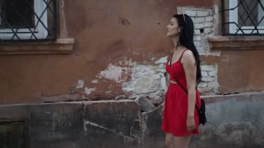 Genç esmer kadın sokakta yürüyor Bratislava şehrinin SLOW MOTION HD VIDEO 'sunda boş zamanlarının tadını çıkarıyor. Yarı hız, kenar görünüm.