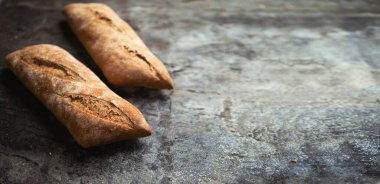 Taze fırın yemeği. Kırsal masa arka planında kızarmış baget ekmeği. Reklam mesajınız veya tanıtım içeriğiniz için sığ DOF ve kopyalama alanı. Pankart genişliği biçimi.