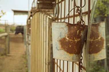 Bir çiftlik arka planında ayna ve zincirli paslı metalik küp.