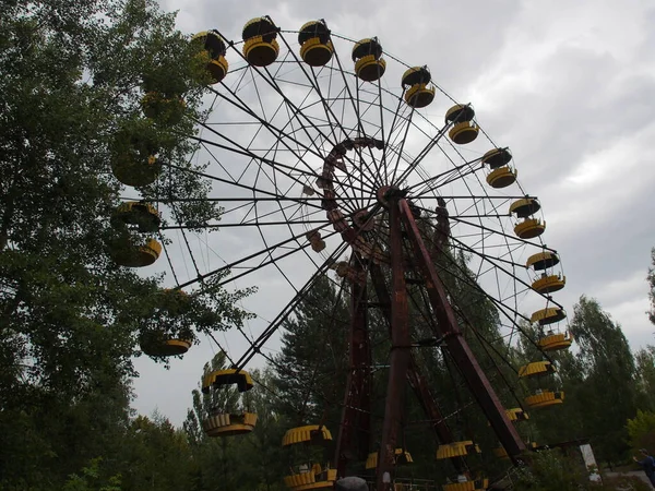 Broken and damaged Ferris wheel. View of the abandoned city of Pripyat, ghost town near the Chernobyl nuclear power plant.