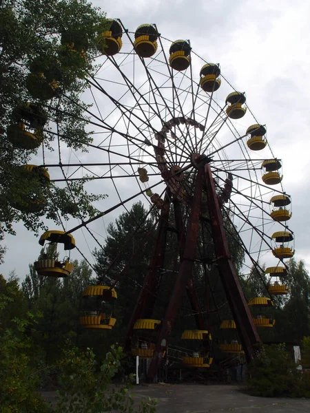 Broken and damaged Ferris wheel. View of the abandoned city of Pripyat, ghost town near the Chernobyl nuclear power plant.