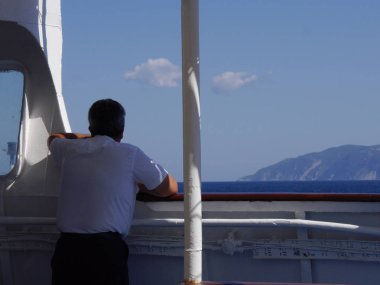 Yunanistan yakınlarındaki güneşli bir yaz gününde, uzaktaki bir Yunan feribotunun kaptanı.