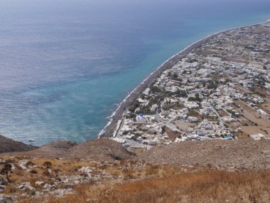 Santorini adasındaki Perissa köyünün panoramik manzarası, dağın tepesinden. Akdeniz ve plajların havadan görünüşü.
