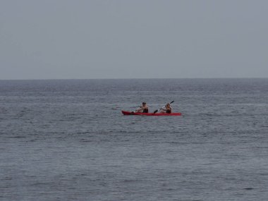 Yunanistan 'ın Perissa Santorini adasında kano üzerinde iki kişi