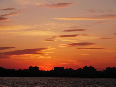 Gün batımında, ağaçların arka planında. Göldeki doğanın yansıması. Elmas Gölü Kiev, Ukrayna.