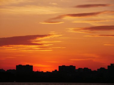 Gün batımında, ağaçların arka planında. Göldeki doğanın yansıması. Elmas Gölü Kiev, Ukrayna.