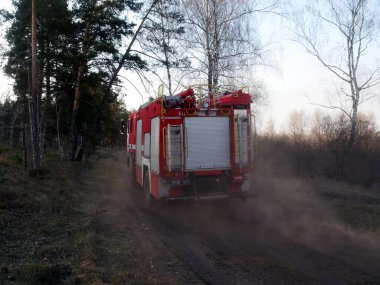 Ormandaki yangını söndürmek için orman yolunda bir itfaiye aracı..
