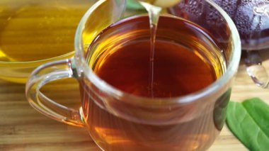 Bal damlıyor bardaktan çaya, yakın plan. 