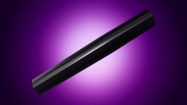 Mor arkaplandaki siyah şişede açma ve döndürme rimelinin animasyonu, pürüzsüz döngünün animasyonu.