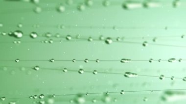 Yeşil zemin üzerinde süzülen su damlalarının soyut animasyonu pürüzsüz döngünün canlandırması