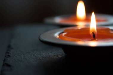 Mum ışığı tepside, siyah bir masada. Resmi kapat.