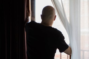 Evde kilitli bir adam var. Pencereden bakıyorum. Covid koronavirüs karantinası