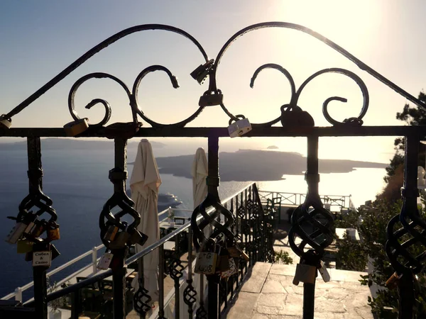 Fira, Santorini, Greece - October 8, 2018: Locks on an iron fence by the sea in Fira.