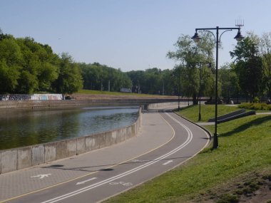 Şehrin merkezinde, Svislach Nehri kıyısında bisiklet yolu olan bir şehir manzarası. Minsk, Belarus. 