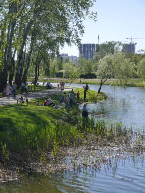 Kiev / Ukraine - April 30, 2018: View of the park with a lake and people relaxing on a sunny spring day.
