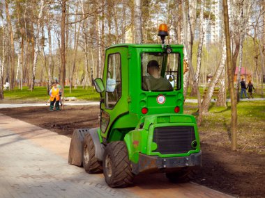 Kiev / Ukraine - April 8, 2019: Spring work in the Peremoga park. Small tractor for park work.