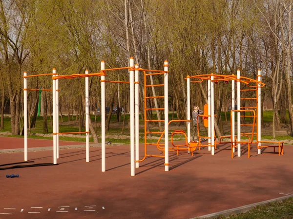 Spor için yatay barları olan bir yer, güneşli bir bahar gününde Peremoga Park 'ta simülatörler. Kiev, Ukrayna.