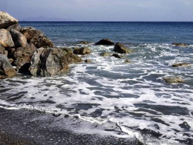 Perissa yakınlarında taşlı deniz manzarası. Santorini Adası, Yunanistan.