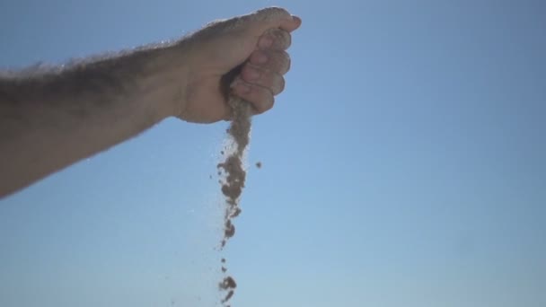 Close up tiro na mão homem próximo na praia, segurando areia da praia e abra lentamente — Vídeo de Stock