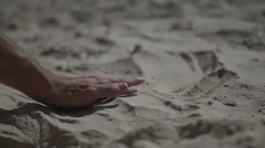 Kumsala dokunan bir adamı yakından çek. Yavaş çekim gerçek hayat.
