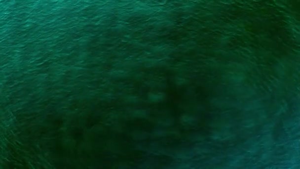 Aérea Sobre la tranquila superficie del agua del océano con ondulaciones azules del mar y olas movimiento lento con rayo de luz solar reflejo del rayo de sol — Vídeos de Stock