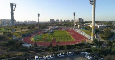 Atletizm pisti stadyumunun üstünde hava aracı atışı. Olimpiyatlara katılan yarışmacılar ve antrenmanlar. 