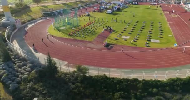 Drone aéreo disparado acima do estádio de pista atlética. pessoas jogging e desafio olímpicos competição e treinamento . — Vídeo de Stock