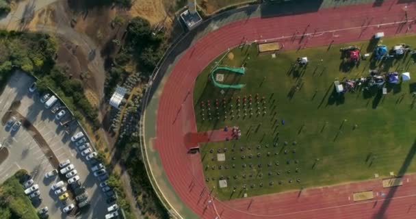 Drone aérien tiré au-dessus du stade athlétique. personnes jogging et défi olympique compétition et formation . — Video