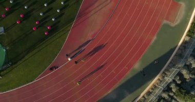 Atletizm pisti stadyumunun üstünde hava aracı atışı. Olimpiyatlara katılan yarışmacılar ve antrenmanlar. 