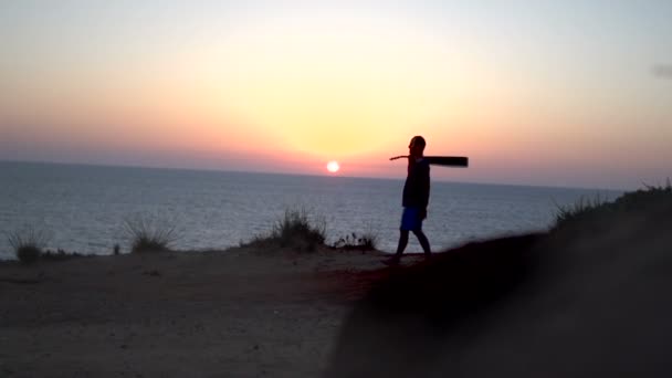 Silhouette di giovane uomo che canta all'aperto suonando la chitarra acustica al tramonto — Video Stock