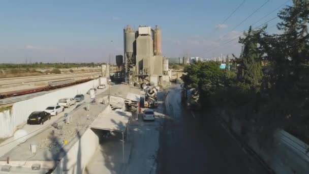 Drohne über Zementfabrik. LKWs beladen und schütten Sand. Industrielles Filmmaterial aufbauen — Stockvideo