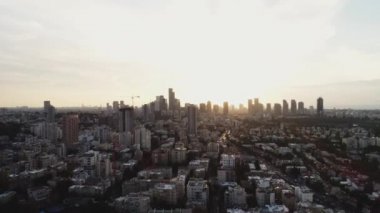 Gündüz vakti gökyüzünde Tel Aviv. Güneş 'e doğru uzanan kulelerin ve binaların ufuk manzarası. Modern şehir arka planının şehir merkezi.