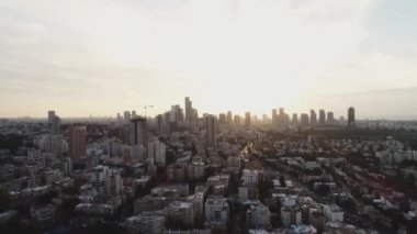 Gündüz vakti gökyüzünde Tel Aviv. Güneş 'e doğru uzanan kulelerin ve binaların ufuk manzarası. Modern şehir arka planının şehir merkezi.