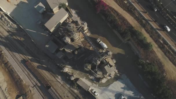 Повітряний безпілотник над цементним заводом. Вантажівки завантажують і заливають піском. Будівництво промислових знімків — стокове відео