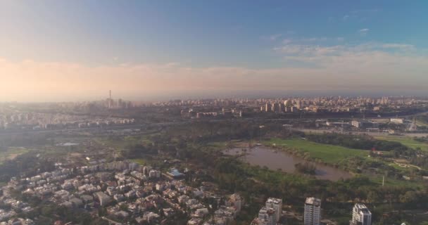 特拉维夫绿天条上的风景，城市绿树成荫的中央公园和池塘上的住宅中的高楼大厦，地平线上的海景. — 图库视频影像