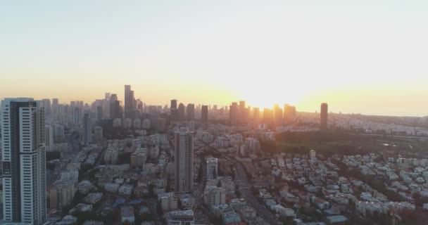 Вид с воздуха над Тель-Авивом на закате, город на Ближнем Востоке в Израиле. Вид на современный городской ландшафт с деловым районом, высотными зданиями и недвижимостью — стоковое видео