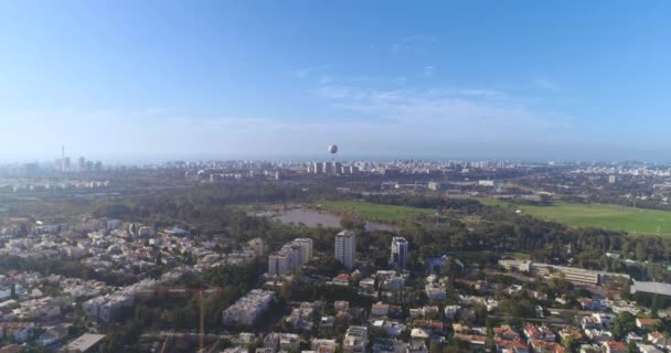 Vacker utsikt över Tel Aviv grön skyline, höghus drönare från bostadshus över grön Central park och damm i stadens skyline utsikt med havsutsikt vid horisonten. — Stockvideo