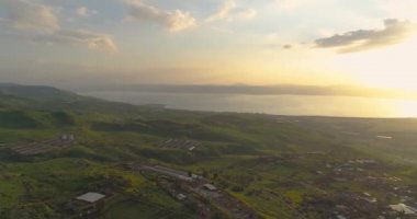 İsrail 'in kuzeyindeki Golan Tepeleri ve Taiberia' da günbatımında hava görüntüleri. Turuncu yeşil manzaralı açık alanlar ve Celile denizi üzerindeki dağlar veya Ürdün vadisinde Kinnert 